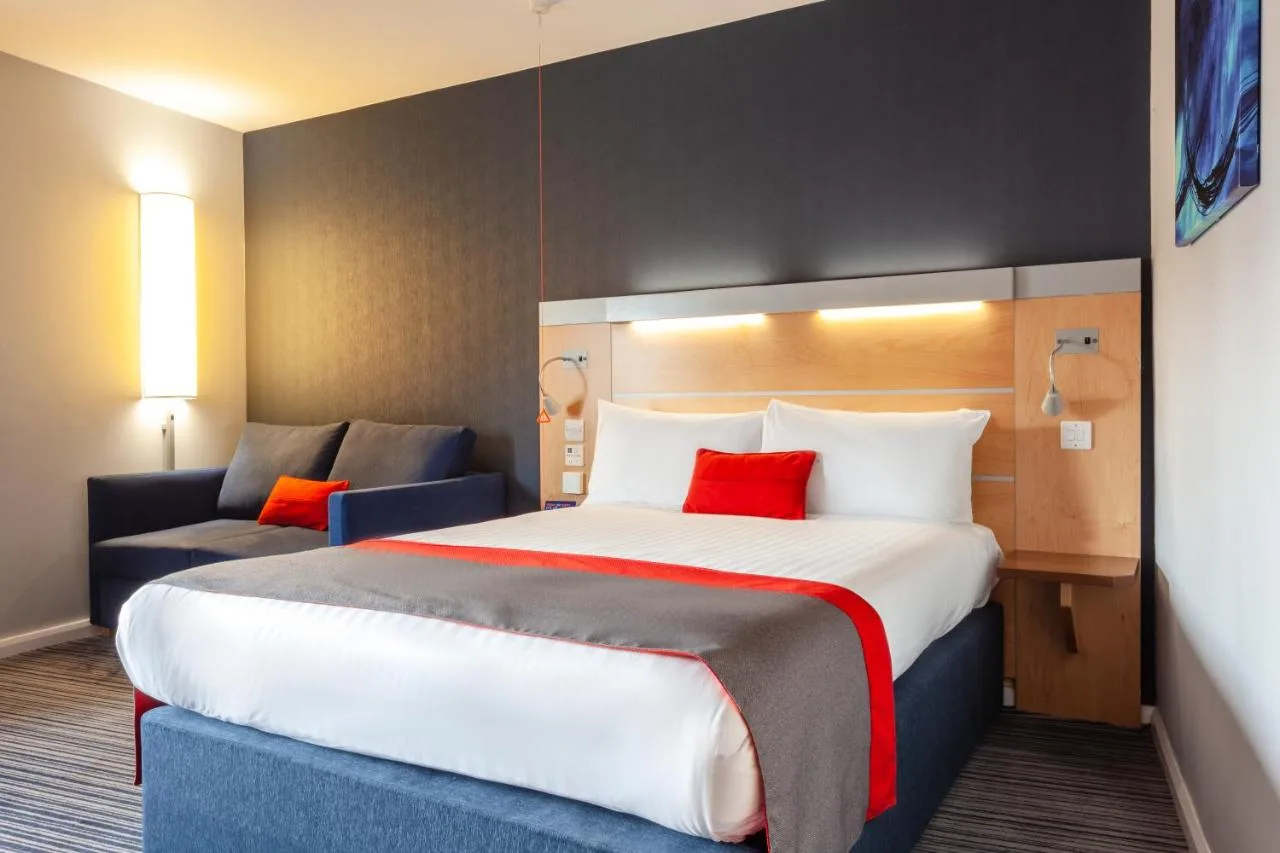 Room with a large bed and sofa at Holiday Inn Express Edinburgh – Royal Mile